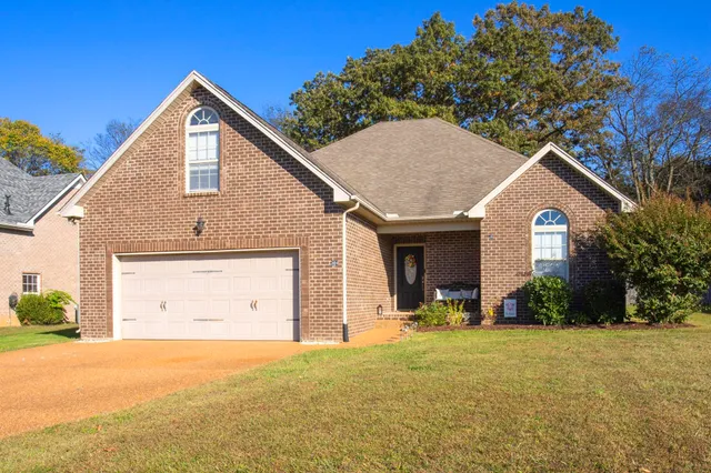 a view of a house with a yard and garage