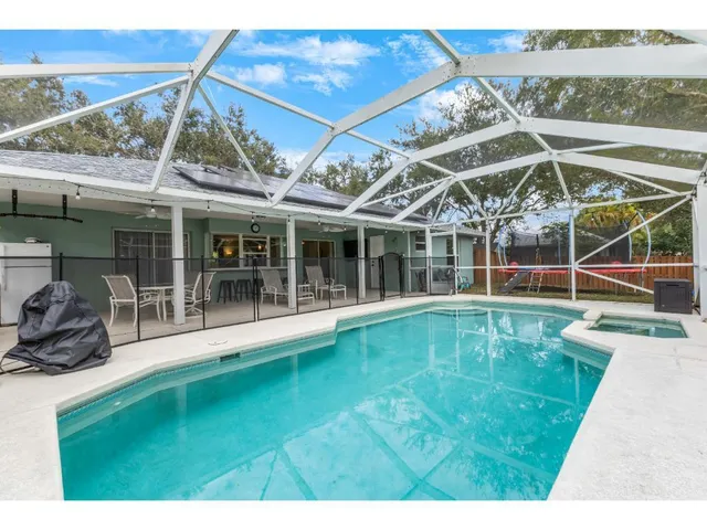 a view of a swimming pool with a patio and a yard
