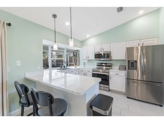 a kitchen with kitchen island a counter top space appliances and a center island