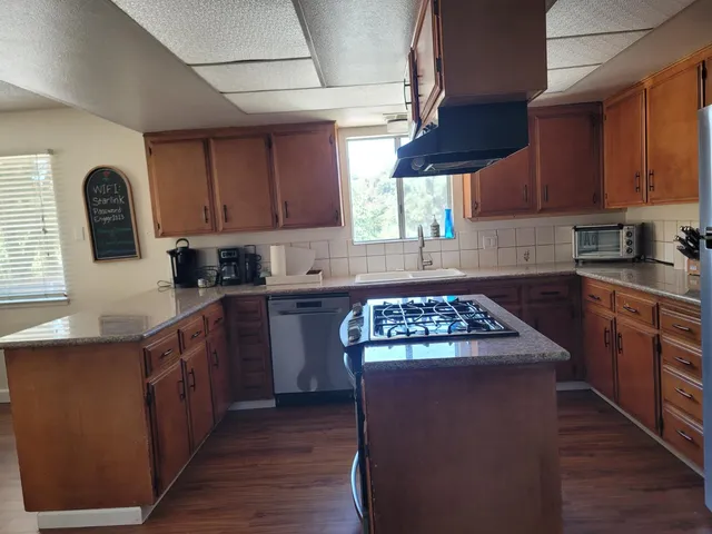 a kitchen with granite countertop a stove sink and cabinets