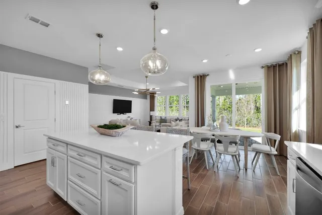 a kitchen with a table chairs and white cabinets