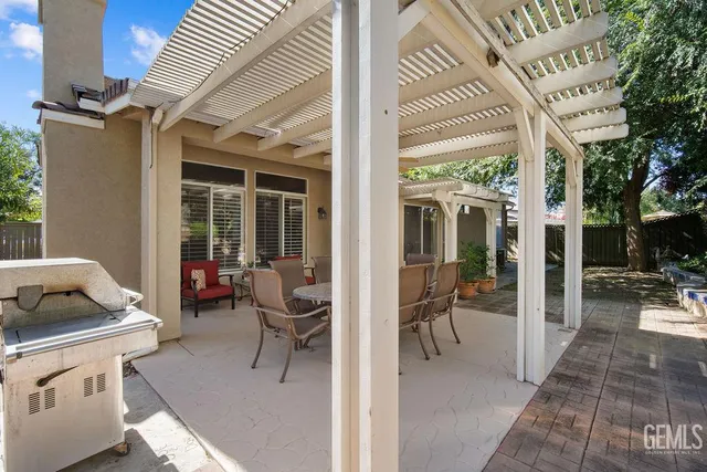 a view of a patio with table and chairs potted plants with floor to ceiling window