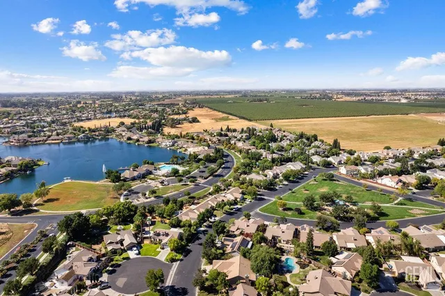 an aerial view of a city with lots of residential buildings and ocean view in back