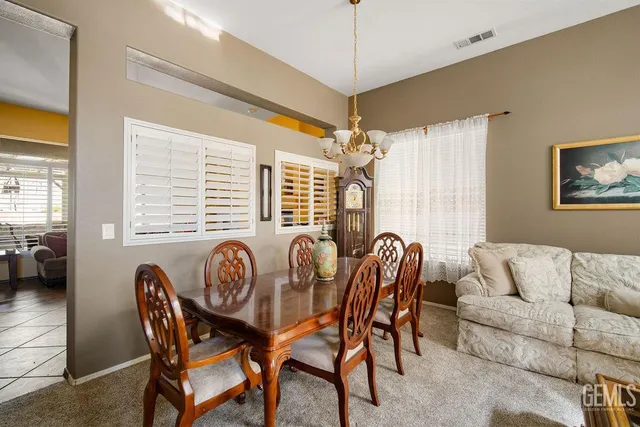 a dining room with furniture a chandelier and window