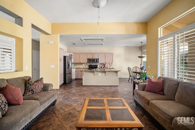 a living room with couches and kitchen view with wooden floor
