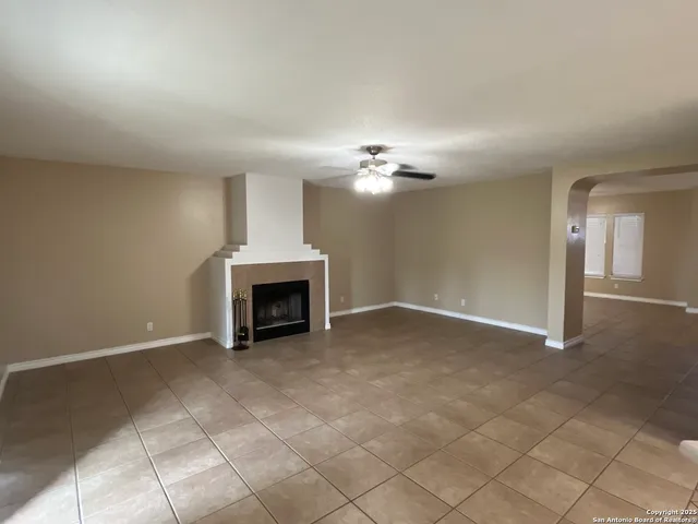 a view of a livingroom with a fireplace and chandelier fan
