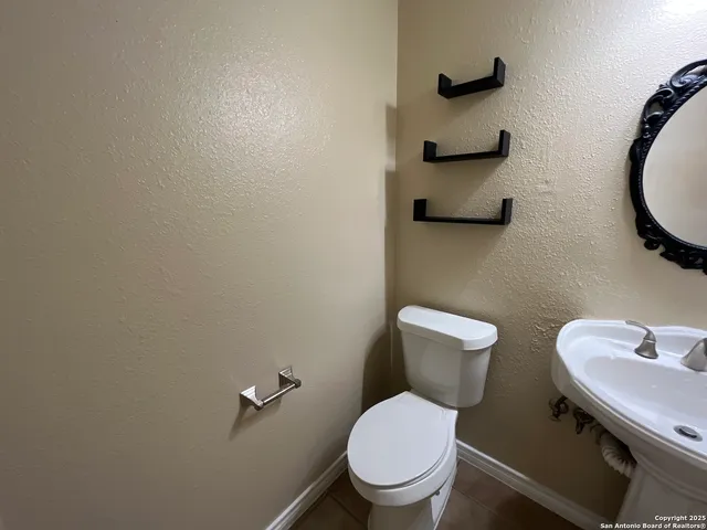 a bathroom with a toilet sink and mirror