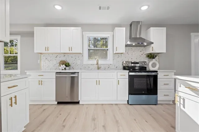 a kitchen with white cabinets stainless steel appliances and sink