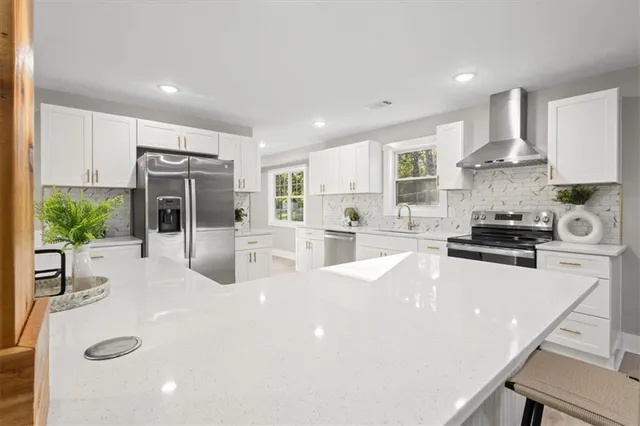 a kitchen with stainless steel appliances a stove a sink a microwave a refrigerator and cabinets