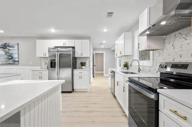 a kitchen with stainless steel appliances granite countertop a sink stove and refrigerator
