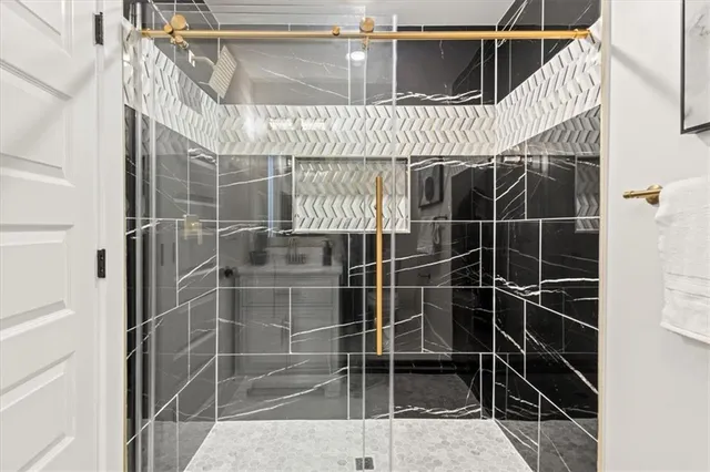 a bathroom with a granite countertop sink toilet and shower