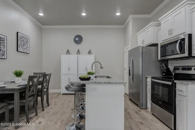 a kitchen with stainless steel appliances granite countertop a stove a sink a microwave and a refrigerator