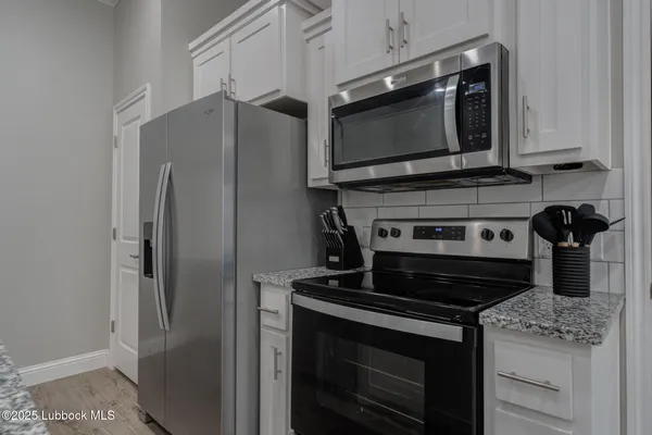 a kitchen with stainless steel appliances granite countertop a stove microwave and refrigerator