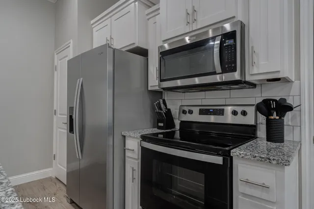a kitchen with stainless steel appliances granite countertop a stove microwave and refrigerator