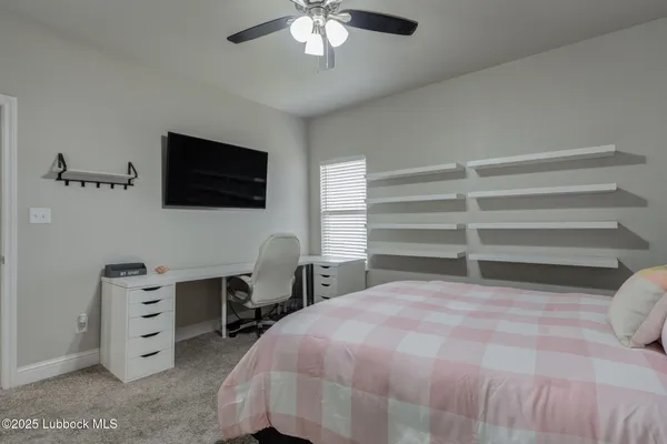a bedroom with a bed and a flat tv screen on wall