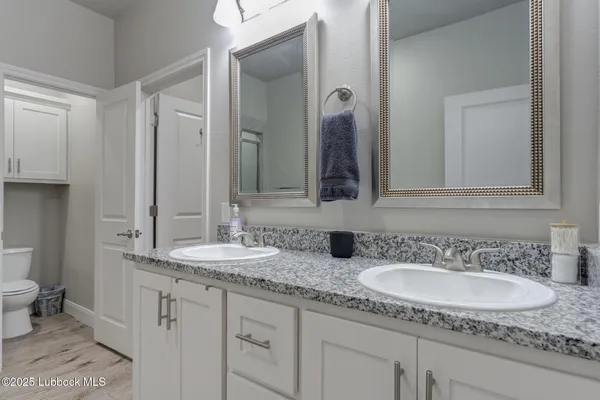 a bathroom with double vanity sinks and a mirror