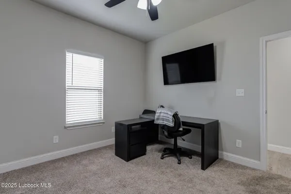 a view of a workspace with furniture and a window