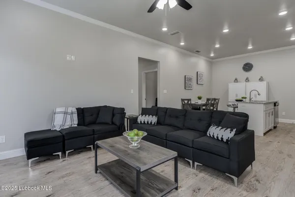 a living room with furniture and a ceiling fan