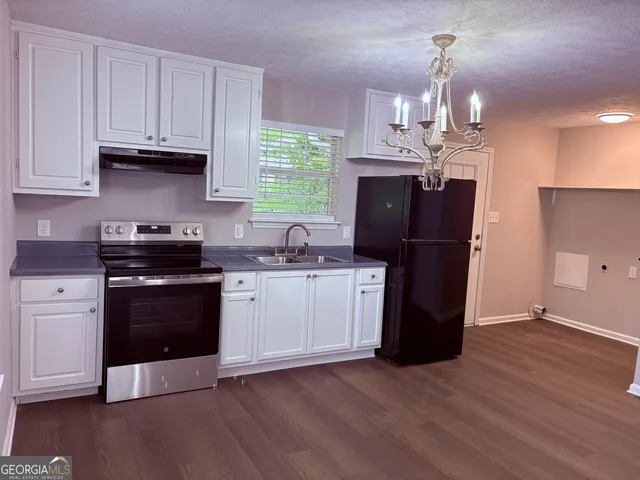 a kitchen with a refrigerator and a stove top oven