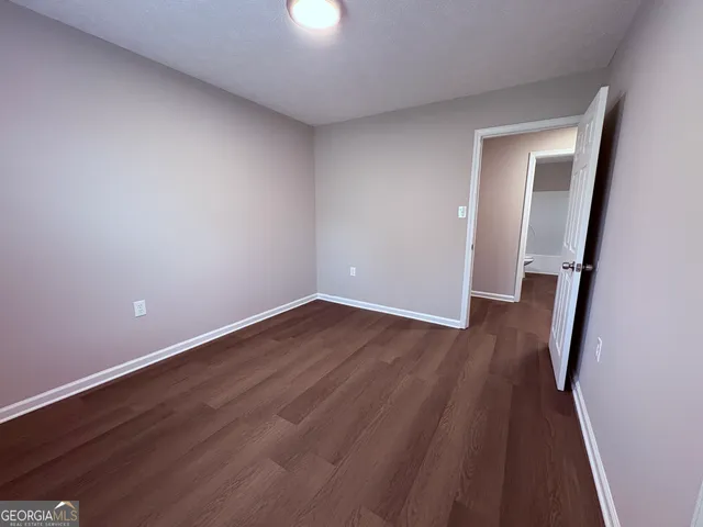 an empty room with wooden floor and entrance