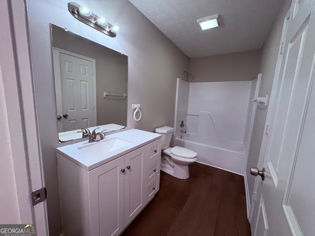 a bathroom with a sink a toilet a mirror and vanity