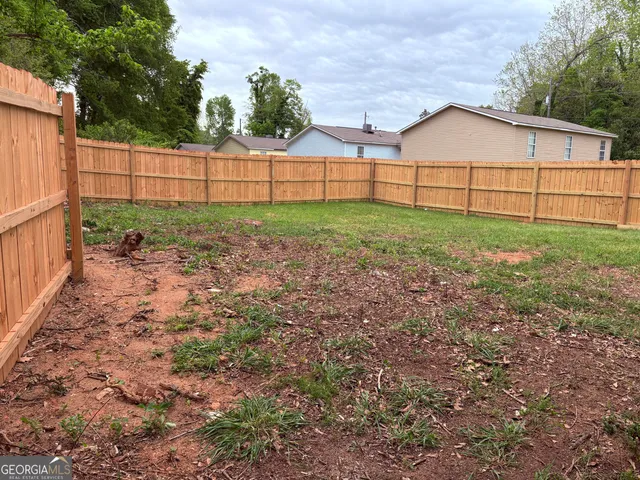 a view of backyard with wooden fence
