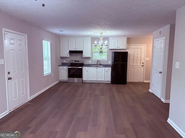 a kitchen with a refrigerator and a stove top oven