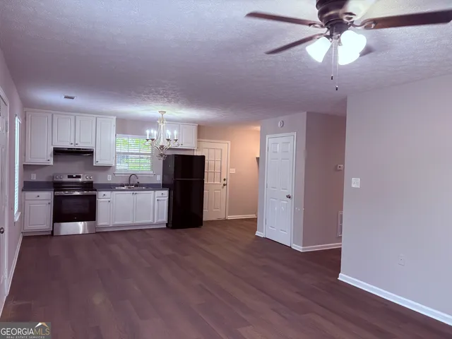 a large kitchen with cabinets wooden floor and stainless steel appliances
