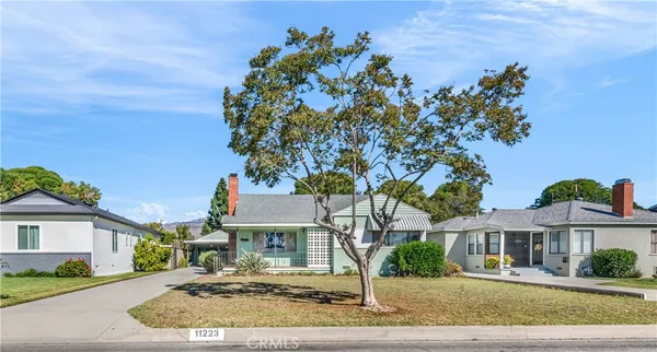 a front view of a house with a tree