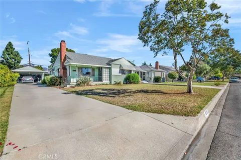 a front view of a house with a yard and trees