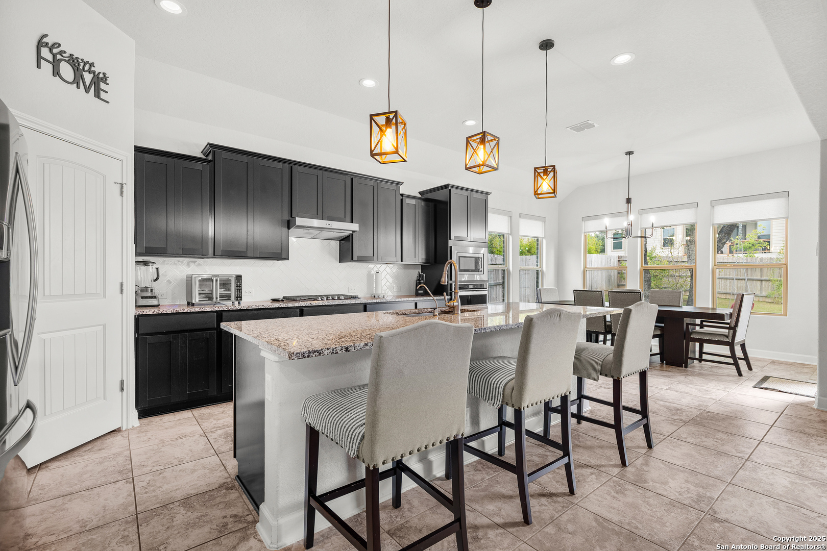 a kitchen with kitchen island granite countertop a sink a center island a counter space stainless steel appliances and cabinets