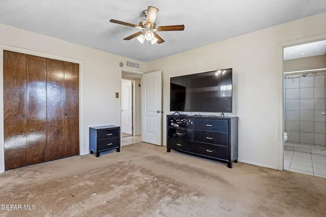 an empty room with a flat screen tv and a dresser