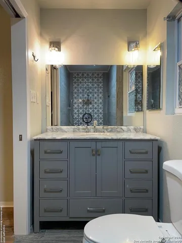 a bathroom with a toilet a sink and mirror