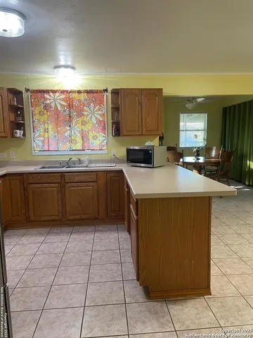 a kitchen with a sink a counter top space cabinets and stainless steel appliances