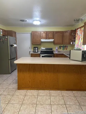 a kitchen with stainless steel appliances granite countertop a refrigerator and a stove top oven