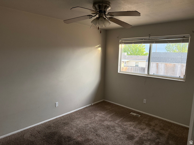 874 770 South Tooele, UT 84074 - Photo 6 of 19 Carpeted interior room featuring a window with horizontal blinds, a ceiling fan with integrated lighting, and neutral wall paint