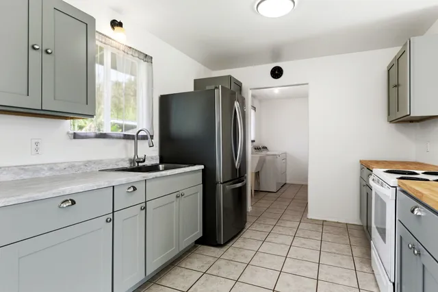 a kitchen with a refrigerator sink and cabinets