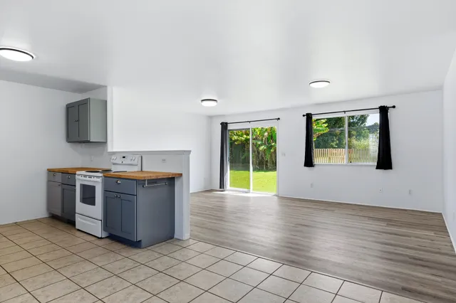 a view of kitchen with granite countertop cabinets and window