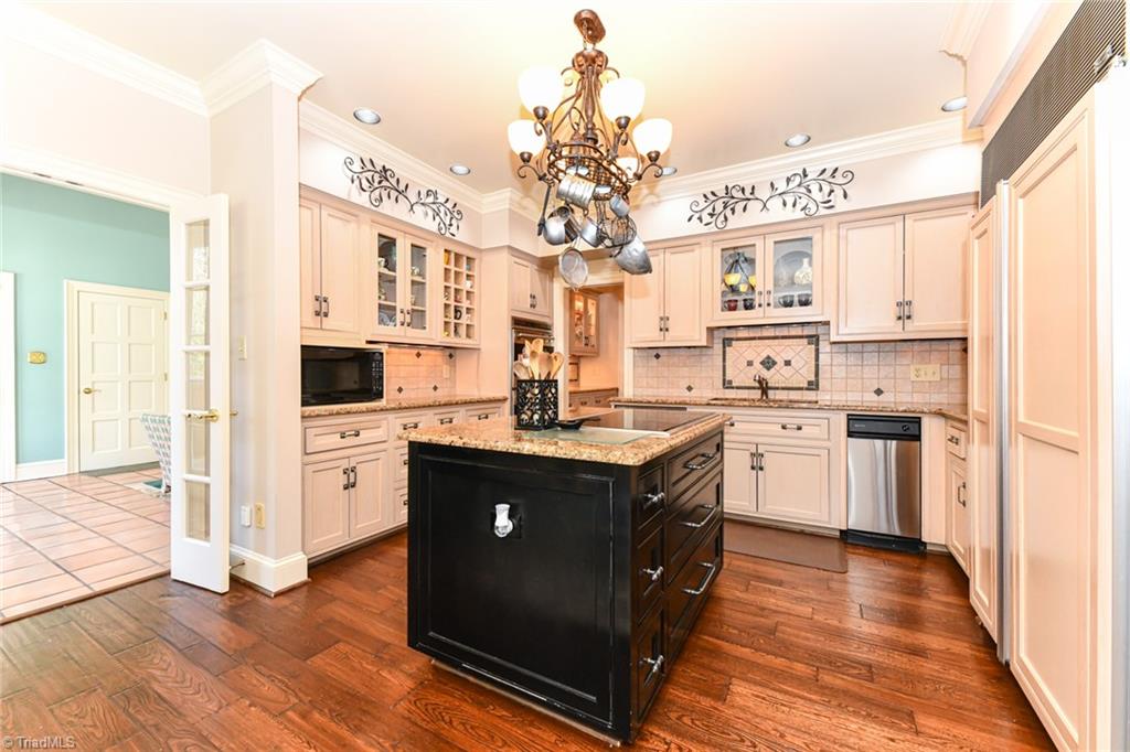 5514 Wayne Road Greensboro, NC 27407 - Photo 7 of 31 The kitchen is the heart of the home - this space has hand scraped hardwood flooring, updated cabinetry, Wolf & Sub-Zero appliances, and island with cooktop.