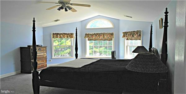 21000 Brooke Knolls Road Laytonsville, MD 20882 - Photo 16 of 20 a bedroom with a bed and a chandelier