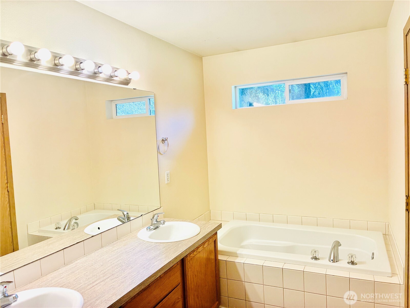 8802 222nd Street East Graham, WA 98338 - Photo 13 of 25 a bathroom with a sink vanity tub and a mirror