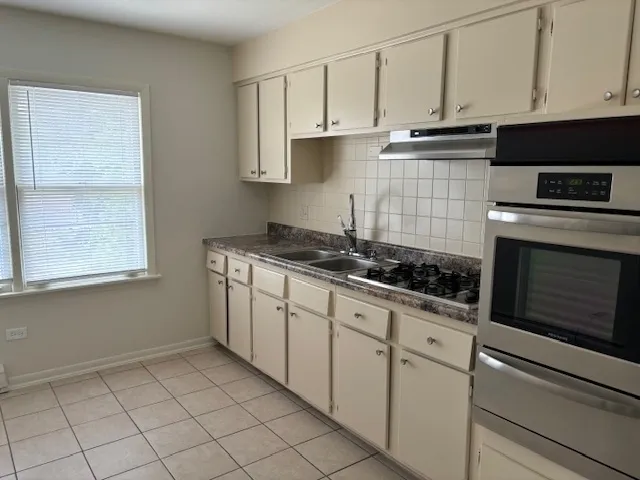 a kitchen with granite countertop white cabinets and appliances