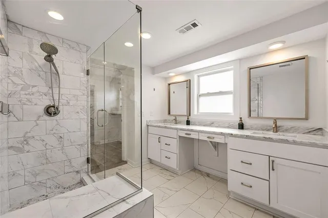 a bathroom with a granite countertop sink mirror and shower
