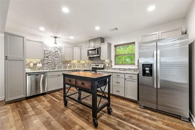 a kitchen with a refrigerator a sink and cabinets