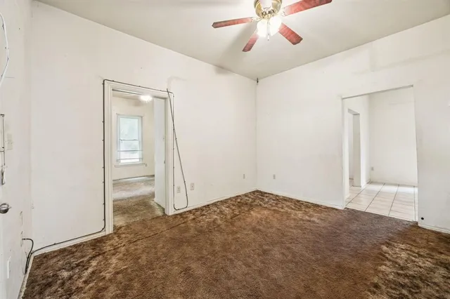 an empty room with closet and fan