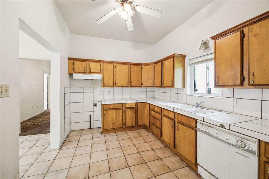 909 East High Street Terrell, TX 75160 - Photo 8 of 24 a kitchen with a sink a stove cabinets and utility room