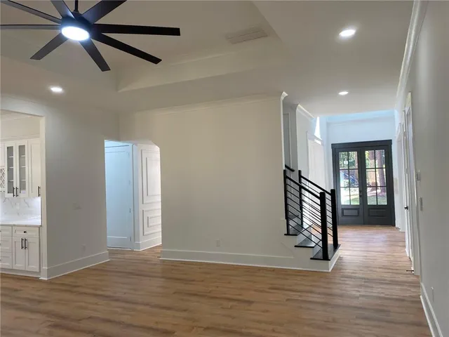 a view of an empty room with wooden floor and a window