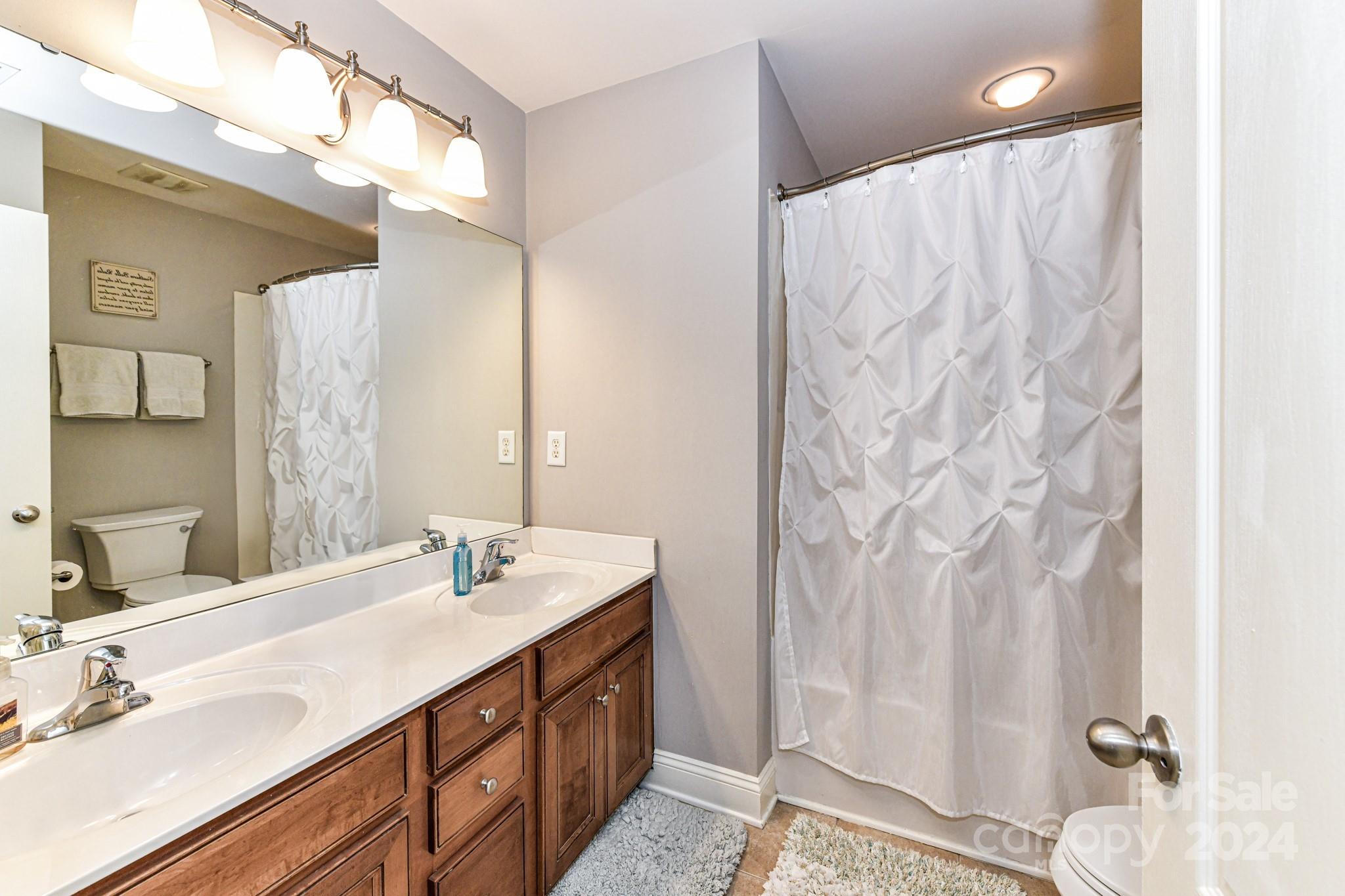 331 Hurston Circle Charlotte, NC 28208 - Photo 15 of 28 a bathroom with a double vanity sink and a mirror