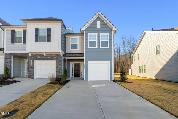 a view of a house with backyard and parking