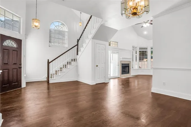 an empty space with kitchen view and wooden floor